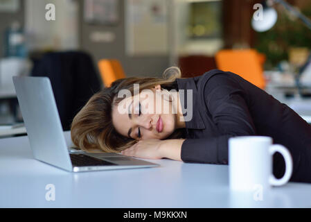 I giovani occupati latino bella donna d'affari di sofferenza lo stress lavorando al computer di ufficio Foto Stock