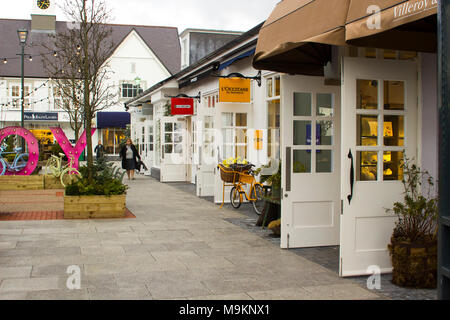 Una donna laden con sacchi da asporto mentre godendosi un po' di terapia al dettaglio presso il mercato di Kildare Village shopping outlet nella contea di Kildare Irlanda Foto Stock