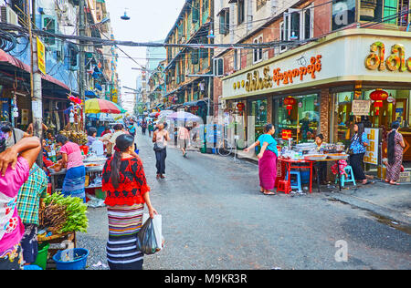 YANGON, MYANMAR - Febbraio 14, 2018: la trafficata strada del mercato di Chinatown con più caffè all'aperto e stand gastronomici, il 14 febbraio a Yangon. Foto Stock