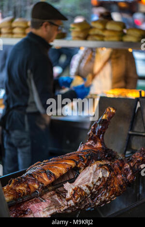 Cibo Astreet stallo a Borough Market nel centro di Londra la vendita di maiale arrosto di maiale o di carne di maiale allo spiedo o rotisserie. Cucinata fresca tirata con la carne di maiale in vendita. Foto Stock