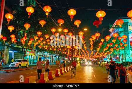 YANGON, MYANMAR - Febbraio 14, 2018: la piacevole passeggiata sotto il Festival di Primavera di lanterne rosse, decorare Maha Bandula Road a Chinatown, a febbraio Foto Stock