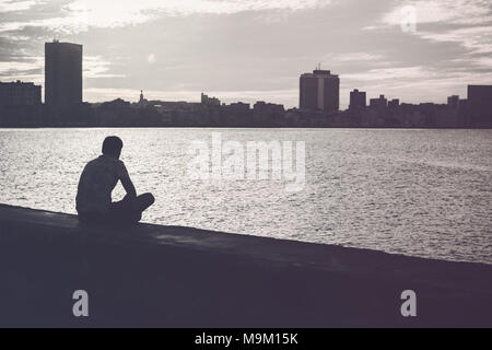 Uomo Orologi il tramonto sulla Skyline di Havana, Cuba Foto Stock