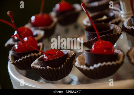 Decorazione su una caramella a tavola con una ciliegia ricoperti di cioccolato Foto Stock