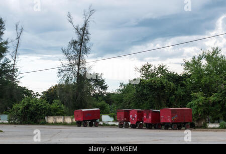 Las Tunas, Cuba - 4 Settembre 2017: Cinque rimorchi rosso, con il nome della società EMGAR dipinta sulla fiancata, parcheggiato su un vuoto molto in città fairgroun Foto Stock