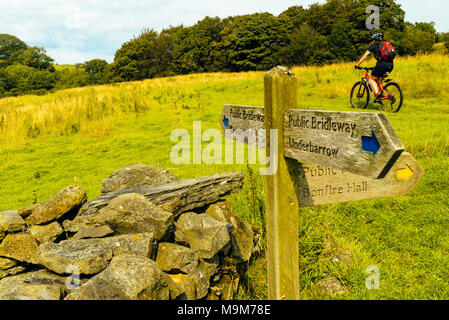 Mountain Biker passando a destra del titolo segni in campagna ad ovest di Kendal Cumbria, Foto Stock