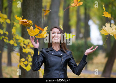 La Bielorussia, Gomel, il 14 ottobre 2017. Giorno di nozze.Una donna è gettare le foglie di autunno Foto Stock