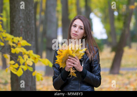 La Bielorussia, Gomel, il 14 ottobre 2017. Giorno di nozze.la ragazza con un mazzo di foglie di autunno Foto Stock