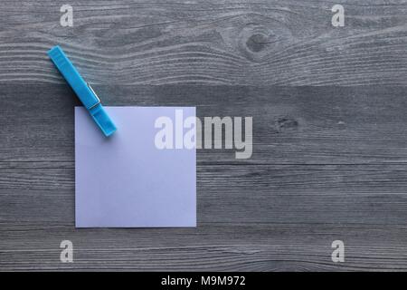 Note scritte a mano su carta bianca, vestiti colorati peg, grigio Sfondo plank, lo spazio per la copia Foto Stock