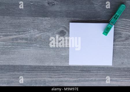 Note scritte a mano su carta bianca, vestiti colorati peg, grigio Sfondo plank, lo spazio per la copia Foto Stock