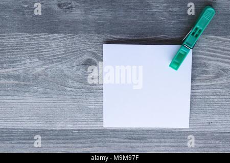 Note scritte a mano su carta bianca, vestiti colorati peg, grigio Sfondo plank, lo spazio per la copia Foto Stock