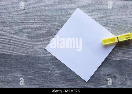 Note scritte a mano su carta bianca, vestiti colorati peg, grigio Sfondo plank, lo spazio per la copia Foto Stock