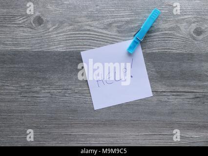 Note scritte a mano su carta bianca, vestiti colorati peg, grigio Sfondo plank, lo spazio per la copia Foto Stock