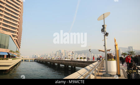 Hong Kong, Cina - 1 Gennaio 2016: Urban i residenti e i turisti a piedi lungo il ponte pedonale sulla costa di Hong Kong al porto di Victoria. Ponte sull'acqua. Vista della città e del mare. Foto Stock