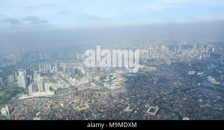 Una vista della città di Manila attraverso la finestra dal piano. Colpito la foto di un turista in volo sopra la capitale. Filippine. Foto Stock