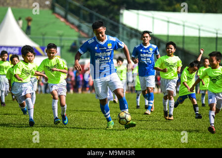 Cinque giocatori di calcio indonesiano club di Persib Bandung giocare contro 85 bambini in un match di esibizione per festeggiare il suo ottantacinquesimo anniversario. Foto Stock