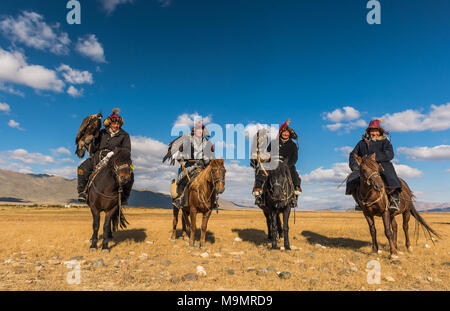 Il mongolo eagle hunters su cavalli nel deserto, Mongolia Foto Stock