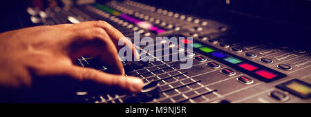 Ritagliate la mano del musicista con mixer audio Foto Stock