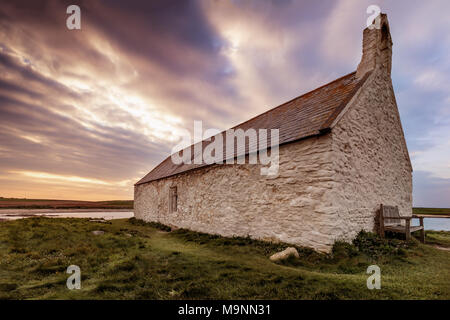 San Cwyfans Chiesa, la piccola Chiesa in mare, si siede sulla piccola isola di Cribinau in Porth Cwyfan Bay, Anglesey, Galles del Nord, Regno Unito Foto Stock