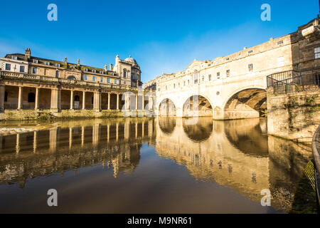 Historic Pulteney Bridge tre archi e la Grand Parade colonne riflessa nella scintillante fiume Avon nella vasca da bagno con un bel cielo blu chiaro Foto Stock