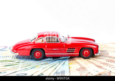 Un classico auto sportiva dell'anno 1954 di colore rosso su fatture in euro con sfondo bianco. Foto Stock