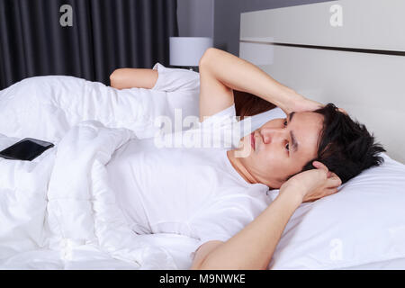 Infastiditi marito bloccando le sue orecchie dal rumore della moglie di russare in camera da letto Foto Stock