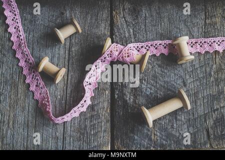 Vitage bobine in legno e pink ribbon retrò su sfondo di legno Foto Stock