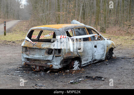 Sonderborg, Danimarca - 24 Marzo 2018: una vettura è stata bruciata su uno spazio di parcheggio in una foresta, la polizia ha segnato il veicolo come scena del crimine. Foto Stock