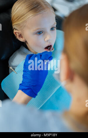 Petite girl subendo la cavità orale checkup a dentisti Foto Stock