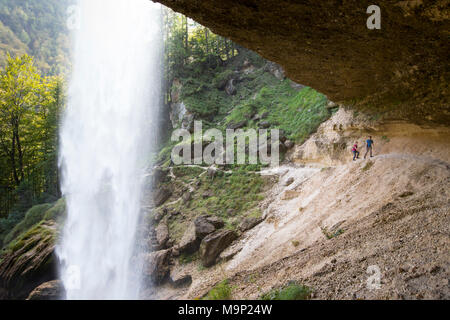 Due persone che camminano su sentiero dietro la cascata Pericnik in alpine valle di Vrata vicino a Mojstrana nel Parco Nazionale del Triglav, Slovenia Foto Stock