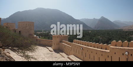 Fortezza Nakhl con torre rotonda e merlature, sul retro Hajar Montagne, Vista panoramica, Nakhl, Oman Foto Stock