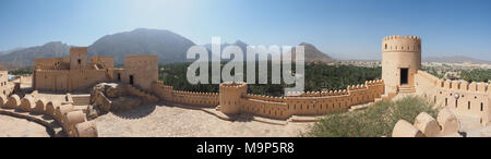 Fortezza Nakhl con torre rotonda e merlature, sul retro Hajar Montagne, Vista panoramica, Nakhl, Oman Foto Stock