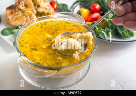 Minestra con gnocchi di patate e carne su un tavolo di legno, una porzione di zuppa bavarese griesnockerl, il fuoco selettivo. Foto Stock
