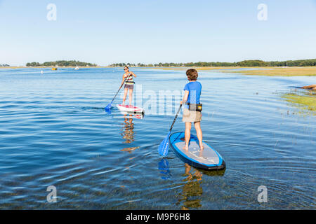 Due donne in piedi up paddle imbarco sul fiume Essex a Cox Prenotazione in Essex, Massachusetts Foto Stock