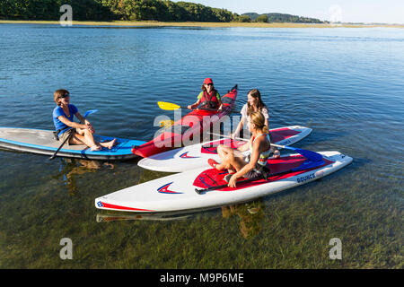 Le donne in piedi up paddle boarding e kayak sul fiume Essex a Cox Prenotazione in Essex, Massachusetts Foto Stock