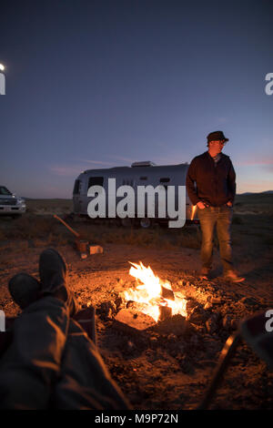 Punto di vista personale colpo di camper intorno al falò di notte, Winnemucca Lago, Nevada, STATI UNITI D'AMERICA Foto Stock