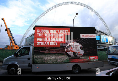 Gruppo di attivisti Avaaz con un cartellone carrello la lettura " Russia non è in grado di ospitare la Coppa del mondo mentre il bombardamento di ragazzi siriano' fuori lo stadio di Wembley, come parte di una campagna per il 2018 Coppa del Mondo per essere trasferito dalla Russia, davanti all'international amichevole tra Inghilterra e Italia. Foto Stock