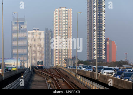 BTS Skytrain rigidi accanto a un per il giro della Papamobile, mattina traffico sul Saphan Taksin Bridge, Bangkok, Thailandia Foto Stock