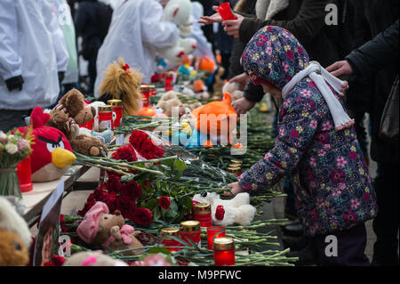 Mosca, Russia. 27 Mar, 2018. Un bambino getta fiori a piangere le vittime di un incendio in un centro commerciale di Kemerovo durante una cerimonia che si terrà a Mosca, in Russia, il 27 marzo 2018. Il presidente russo Vladimir Putin martedì ha firmato un decreto che dichiara mercoledì una giornata di lutto nazionale per le vittime di un incendio di grandi proporzioni in un centro commerciale nella città siberiana di Kemerovo, che ha ucciso almeno 64 persone su 25 Marzo. Credito: Evgeny Sinitsyn/Xinhua/Alamy Live News Foto Stock