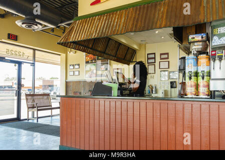 Un dipendente ha un ordine al telefono, entra in un computer al parafango, una ala di pollo Ristorante e bar sport. Stati Uniti d'America, Oklahoma City, Oklahoma Foto Stock