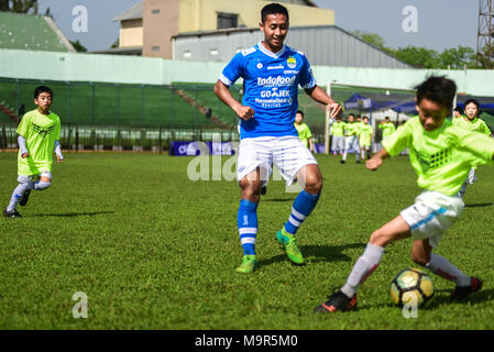 Cinque giocatori di calcio indonesiano club di Persib Bandung giocare contro 85 bambini in un match di esibizione per festeggiare il suo ottantacinquesimo anniversario. Foto Stock