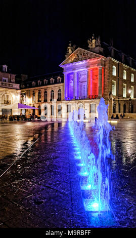 Di notte a luogo Liberacion, Dijon, Borgogna con fontane e piazza illuminata con i colori della bandiera francese. Foto Stock