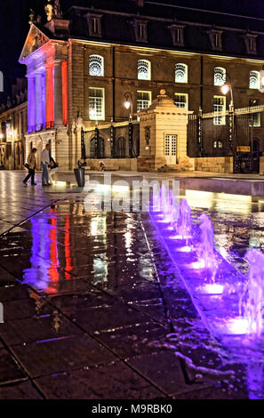 Di notte a luogo Liberacion, Dijon, Borgogna con fontane e piazza illuminata con i colori della bandiera francese. Foto Stock