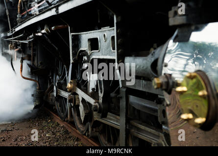 Close up dettaglio del motore a vapore le ruote motrici e la lavorazione di pezzi su operativa locomotiva vintage Foto Stock