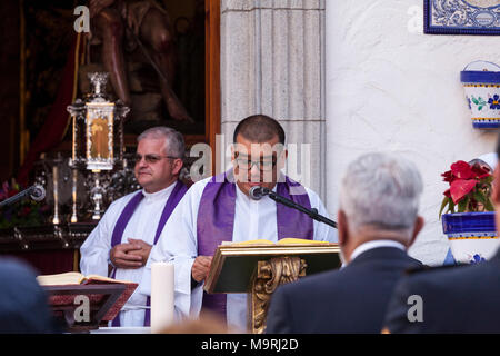 Il sacerdote che celebra la messa fuori la Ermita de la Viña in Adeje old town, Tenerife, Isole Canarie, Spagna Foto Stock