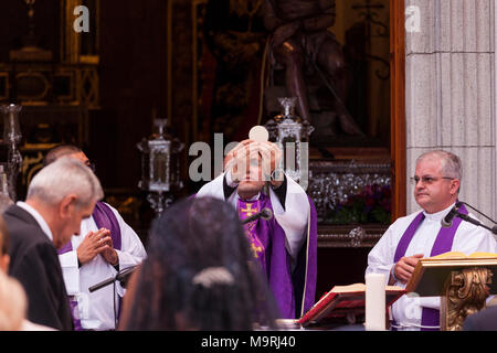 Sacerdote di celebrare la Messa, tenendo l'host, la comunione al di fuori la Ermita de la Viña in Adeje old town, Tenerife, Isole Canarie, Spagna Foto Stock