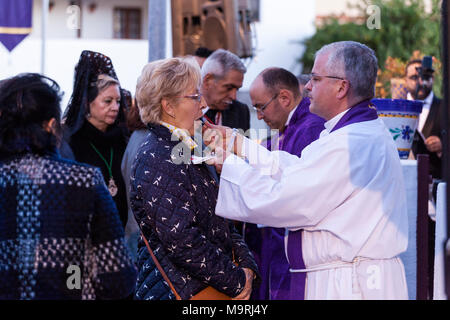 Il sacerdote che celebra la Messa, dare la comunione host, pane azzimo, fuori la Ermita de la Viña in Adeje old town, Tenerife, Isole Canarie, Spai Foto Stock