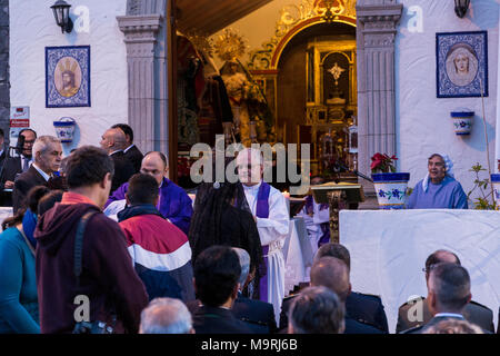 Il sacerdote che celebra la Messa, dare la comunione host, pane azzimo, fuori la Ermita de la Viña in Adeje old town, Tenerife, Isole Canarie, Spai Foto Stock