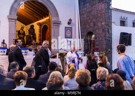 Il sacerdote che celebra la Messa, dare la comunione host, pane azzimo, fuori la Ermita de la Viña in Adeje old town, Tenerife, Isole Canarie, Spai Foto Stock