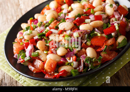 Cibo turco: Piyaz con insalata di fagioli, pomodori, cipolle, peperoni e coriandolo close-up su una piastra sul tavolo orizzontale. Foto Stock