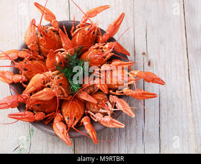 Vecchia ciotola con rosso di aragosta bollita su un tavolo in legno in stile rustico, close-up, il fuoco selettivo su alcuni crawfishes Foto Stock